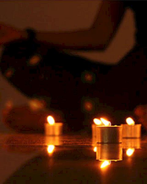 A person in a meditative pose surrounded by lit candles, creating a serene and peaceful atmosphere.